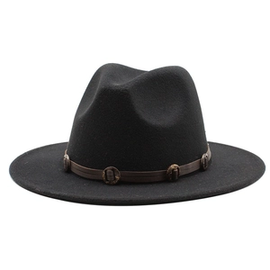 Detail of black fedora hat featuring a brown leather band with decorative metal rings