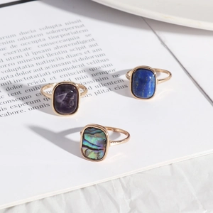 Detail of vintage gold rings with rectangular amethyst, lapis, and abalone shell inlays