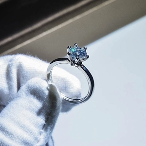 Macro view of a six-prong silver ring featuring a brilliant-cut round solitaire diamond