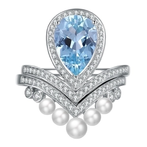 Detailed close-up of a pear-cut aquamarine ring set with V-shaped pearl accent bands