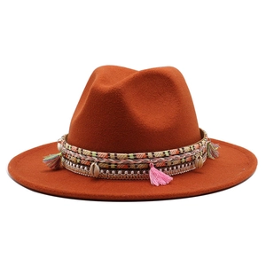 Detail of orange wool fedora with bohemian braided band, tassels and shell charms