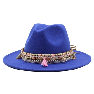 Detail of royal blue wool felt hat featuring ethnic woven band with shells and colorful tassels