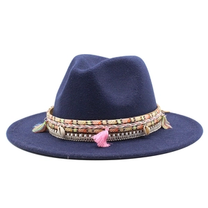 Detail of navy blue wool fedora featuring bohemian tassels and sea shell decorative band