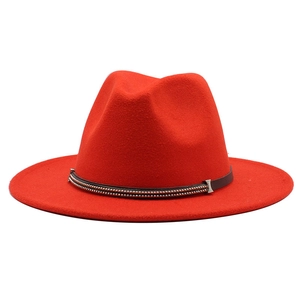 Close-up of red wool fedora hat with brown leather band and silver bead detailing