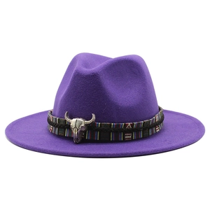 Detail of dark purple wool fedora hat featuring a bull skull ornament and ethnic band