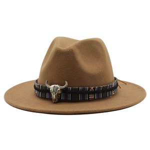 Close-up of brown wool fedora hat featuring ethnic woven band and silver bull skull charm