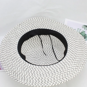 Macro view of wide brim straw hat interior showing sweatband and woven texture