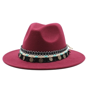 Dettaglio cappello fedora bordeaux con nappe nere e decorazioni con monete metalliche rétro