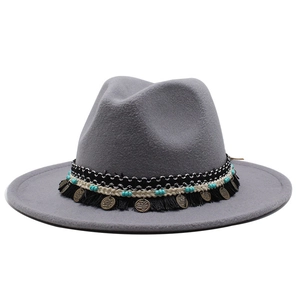 Dettaglio cappello in feltro grigio con perline turchesi e ciondoli a moneta bronzei