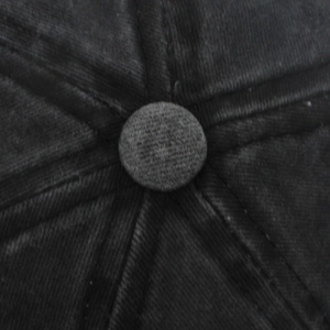Macro view of washed cotton twill crown with 6-panel stitching and top button on baseball cap