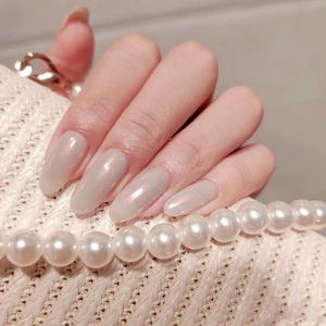 Macro shot of long oval pearl grey press-on nails with aurora shimmer and elegant finish