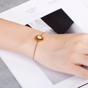 Minimalist gold teardrop pendant bracelet with sparkling stones on model wrist