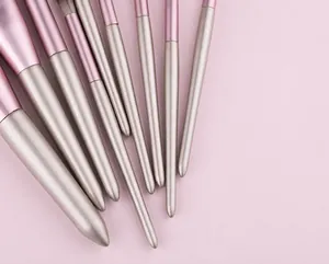 Detail of tapered champagne pearlescent makeup brush handles with purple metal ferrules