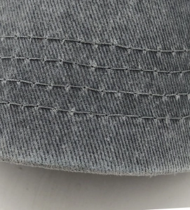 Detailed macro view of gray washed cotton army cap showing parallel stitching and raw edges