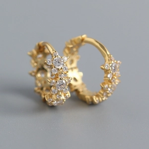 Macro shot of gold S925 sterling silver star hoop earrings with sparkling zircon crystals