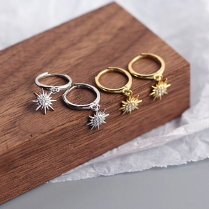 Macro view of S925 sterling silver sunburst hoop earrings in gold and silver finishes