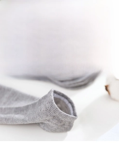 Macro shot of grey disposable ankle socks showing elastic non-slip cuff detail