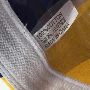 Detailed view of 100% cotton material tag and care labels inside the propeller baseball cap