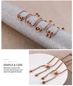 Détail d'un bracelet en or rose avec lettres de style bambou et fermoir réglable avec cœur