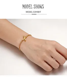 Dettaglio di un braccialetto d'oro in acciaio inossidabile con design a bambù incrociato