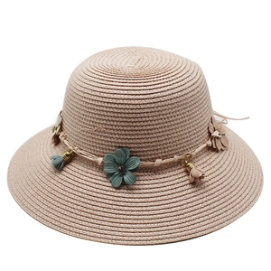 Foldable floral straw sun hat for women with pink and green fabric flowers on white background