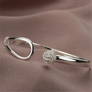 Macro detail of silver rose flower carving and polished open cuff bracelet texture