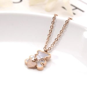 Détail du pendentif ours en or rose avec nacre et breloque cœur gravée Love