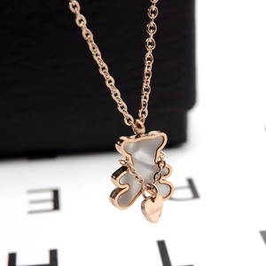 Macro d'un collier ours en or rose 18K avec nacre blanche et pendentif coeur gravé Love