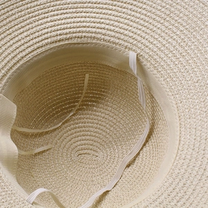 Detail of straw sun hat interior with adjustable inner string and woven sweatband