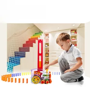 Detail eines Kindes, das mit dem automatischen elektrischen Dominozug in Innenräumen spielt