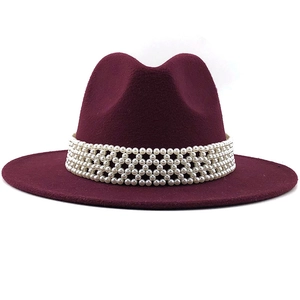 Détail d'un chapeau fedora en laine bordeaux avec un élégant ruban de perles à quatre rangs