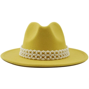 Close-up of a bright yellow wool fedora hat featuring an elegant pearl woven band detail