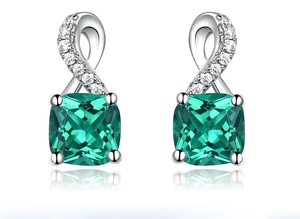 Close-up of square emerald stone earrings with silver twisted diamond settings