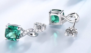 Close-up of S925 sterling silver earrings featuring square emerald stones and diamonds