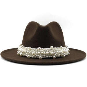 Detailed view of the layered white pearls decorating the brim of a brown wool fedora hat