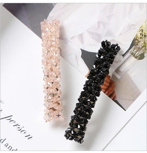 Close-up of champagne and black crystal hair clips with four rows of faceted beads
