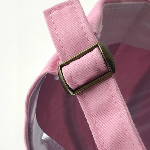 Close-up of pink cotton baseball cap with adjustable bronze metal buckle and strap