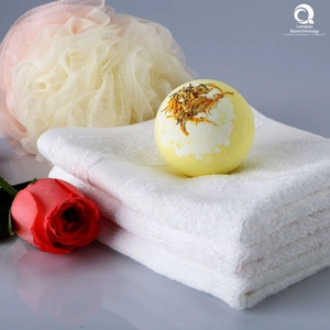 Gros plan détaillé d'une bombe de bain jaune avec fleurs séchées sur une serviette