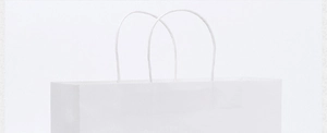 Detail of a minimalist white paper shopping bag with reinforced white carry handles