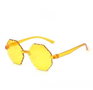 Detail of yellow rimless sunglasses featuring unique wave-cut octagonal lenses in jelly tint