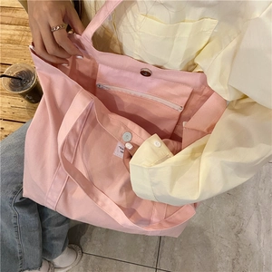Detail view of pink canvas tote bag showing magnetic closure and internal zipper pocket