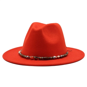 Detailed close-up of a red wool fedora hat featuring a vintage beaded decorative band