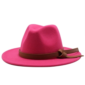Detail of rose red wool fedora hat with wide brim and decorative brown leather belt band
