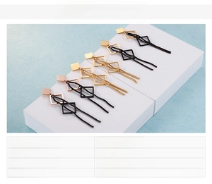Détail de boucles d'oreilles pendantes géométriques en acier inoxydable doré et noir