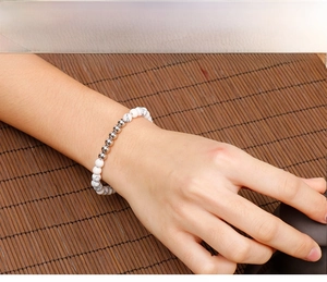 Detail of white turquoise beaded bracelet with silver metal beads on model wrist