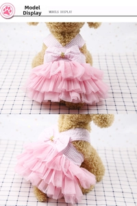 Detail of pink layered tutu pet dress featuring a checkered bow and gold bead accents