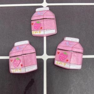 Close-up of pink strawberry milk resin charms for DIY phone cases and hair accessories