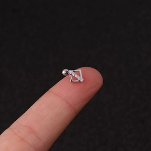 Close-up of a silver geometric square stud earring with zircon on a finger