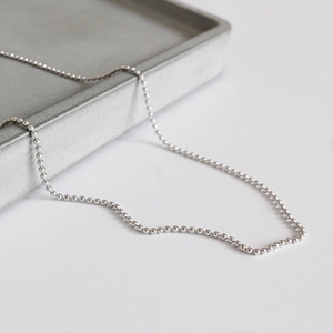 Minimalist S925 sterling silver bead chain necklace for women on a gray minimalist tray