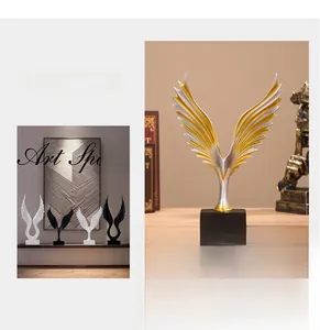 Detail van Scandinavische abstracte vleugelsculpturen in goud, zilver en wit op zwarte voet